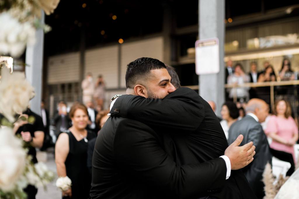 VIEW-BY-SYDNEY-PIER-ONE-WEDDING-PHOTOGRAPHER-ANELLOWEDDINGS-HUG-FATHER-SON-IN-LAW