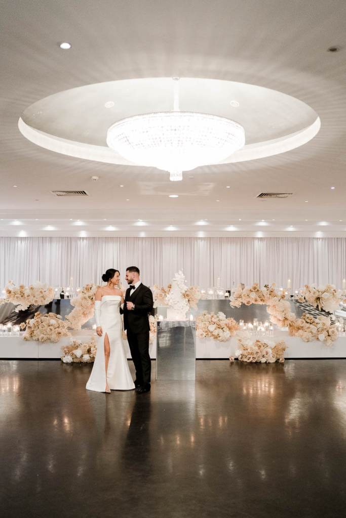 bride and groom standing infront of table