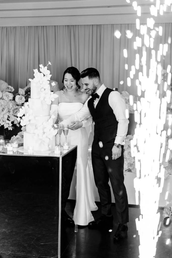 bride and groom cut wedding cake with sparklers