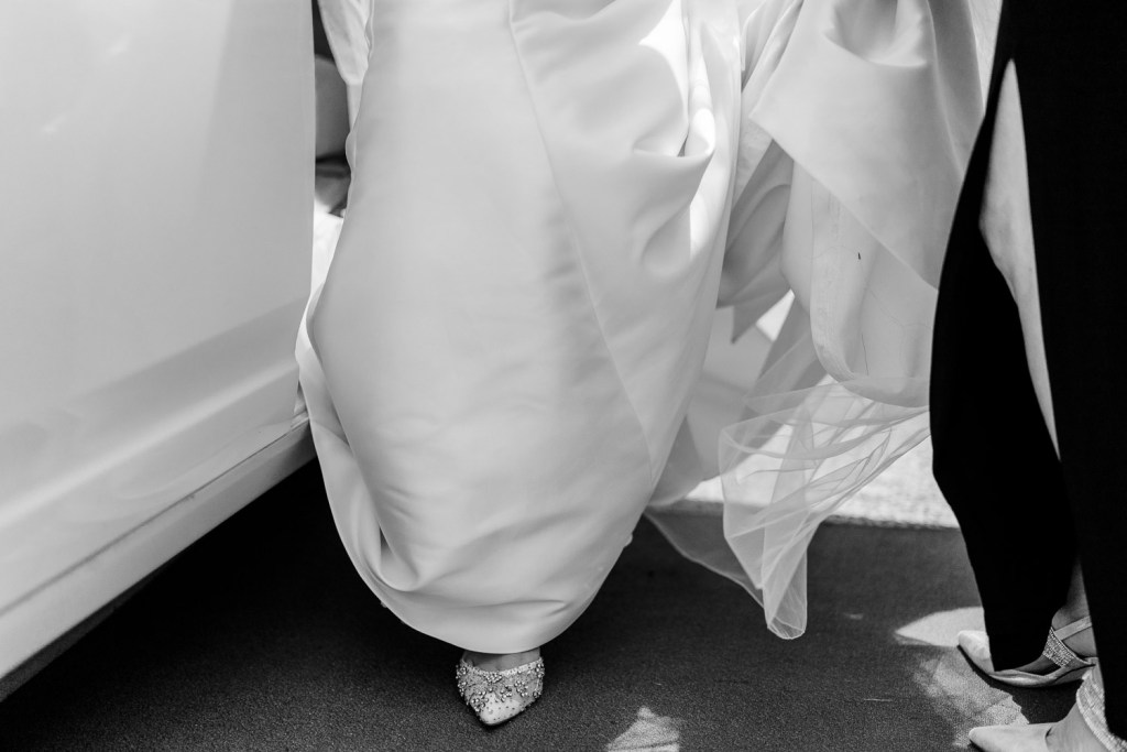 bride stepping out of car with dad