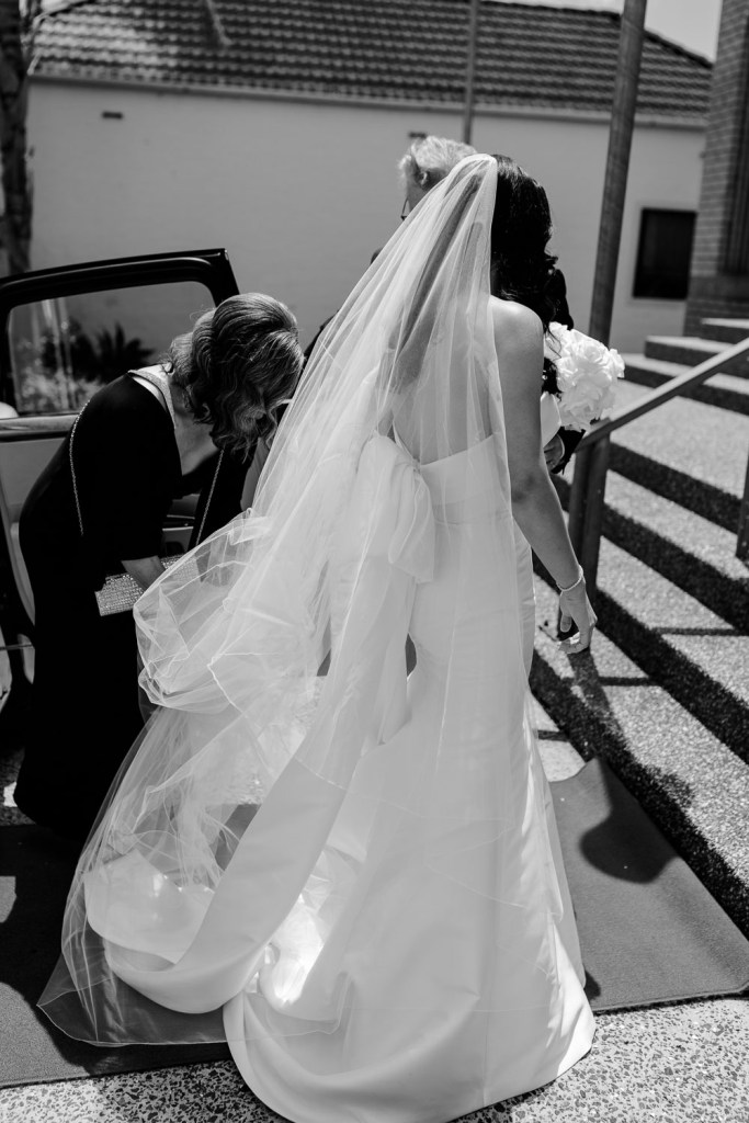 bride stepping out of car with dad