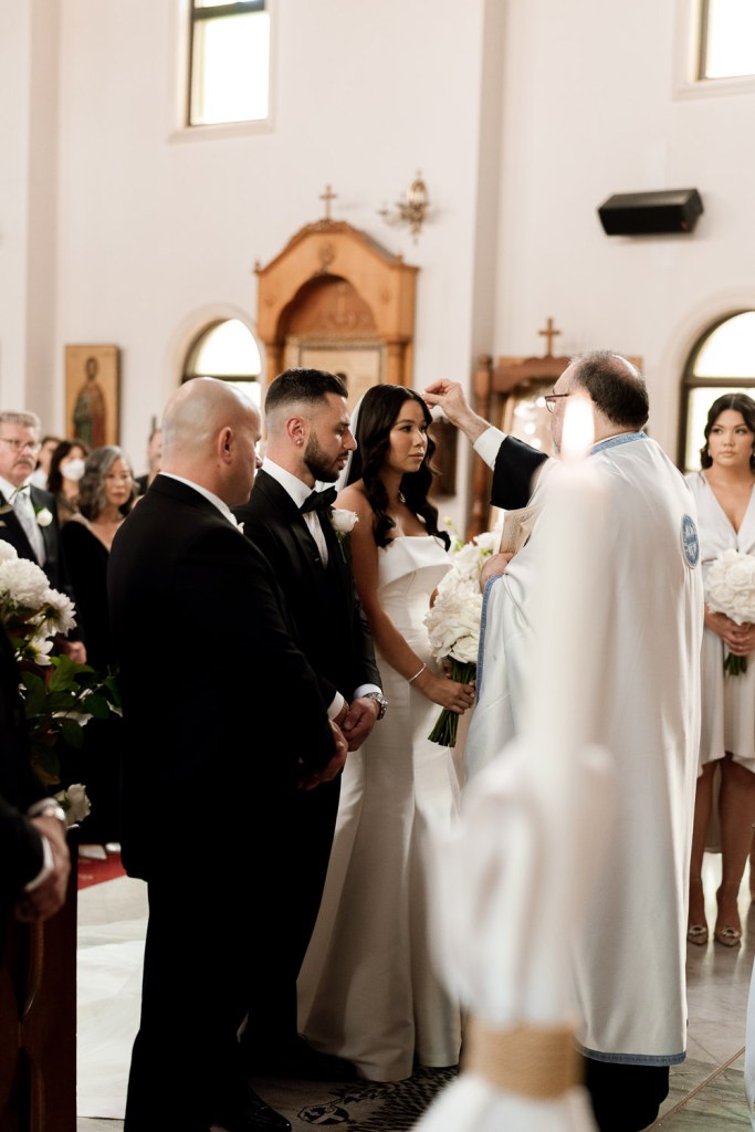 priest touching brides head