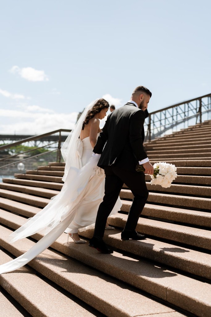 bride and groom walking up stairs