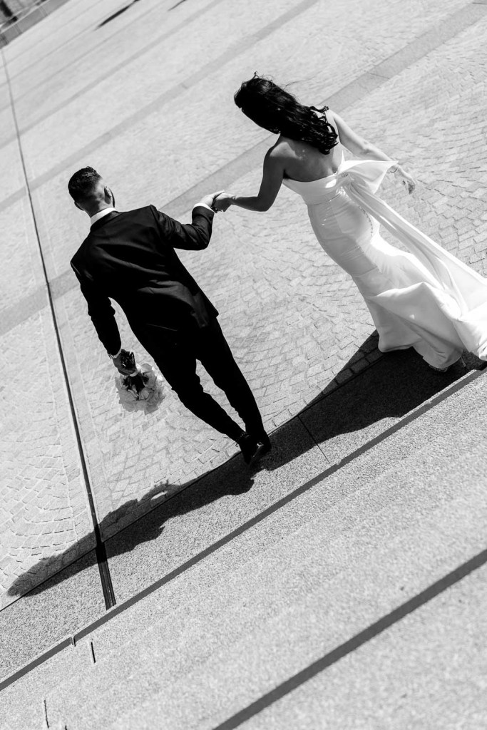 groom walking bride down stairs black and white