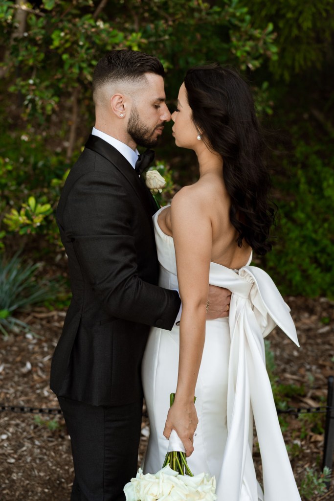 bride and groom in garden kissing