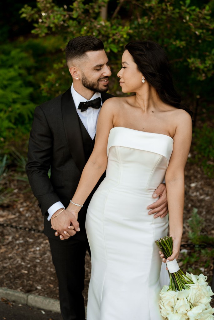 groom kissing bride in garden