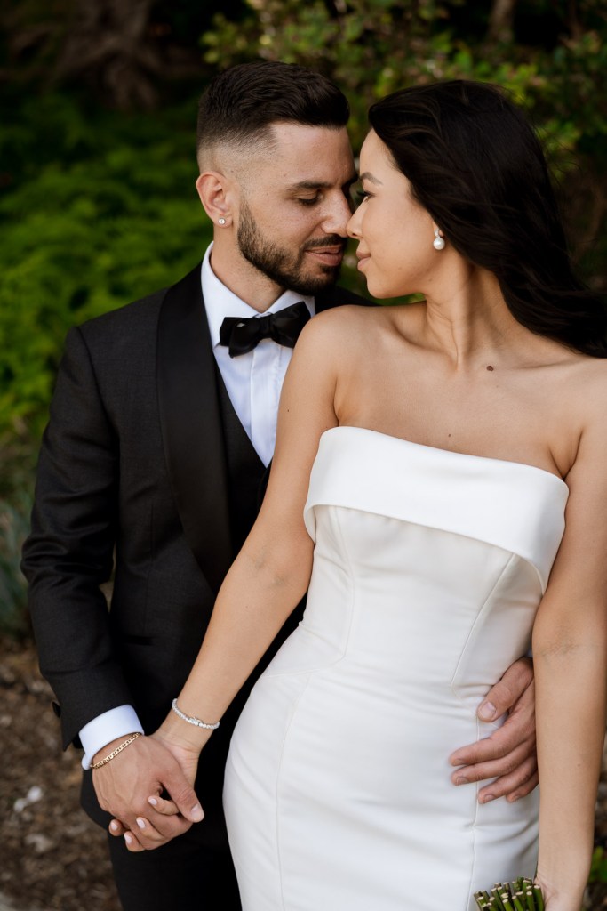 bride and groom holding hands together in garden