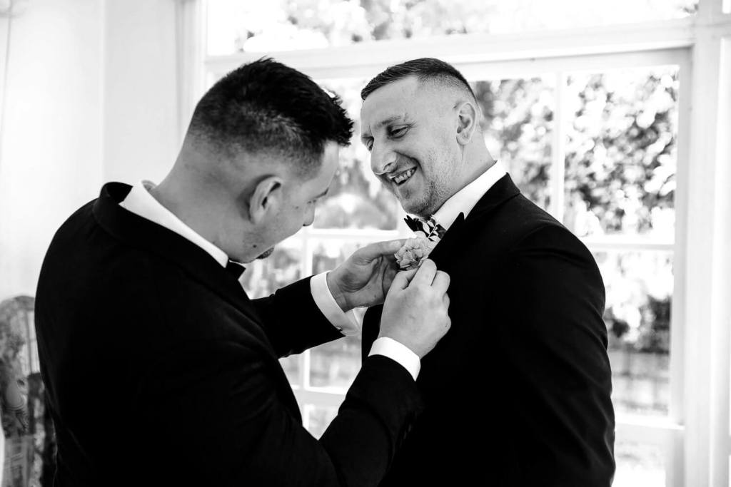 Putting flower on groom
