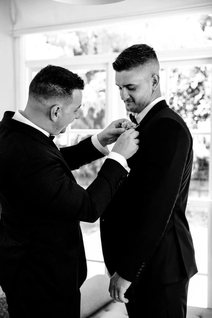 Putting flower on groom