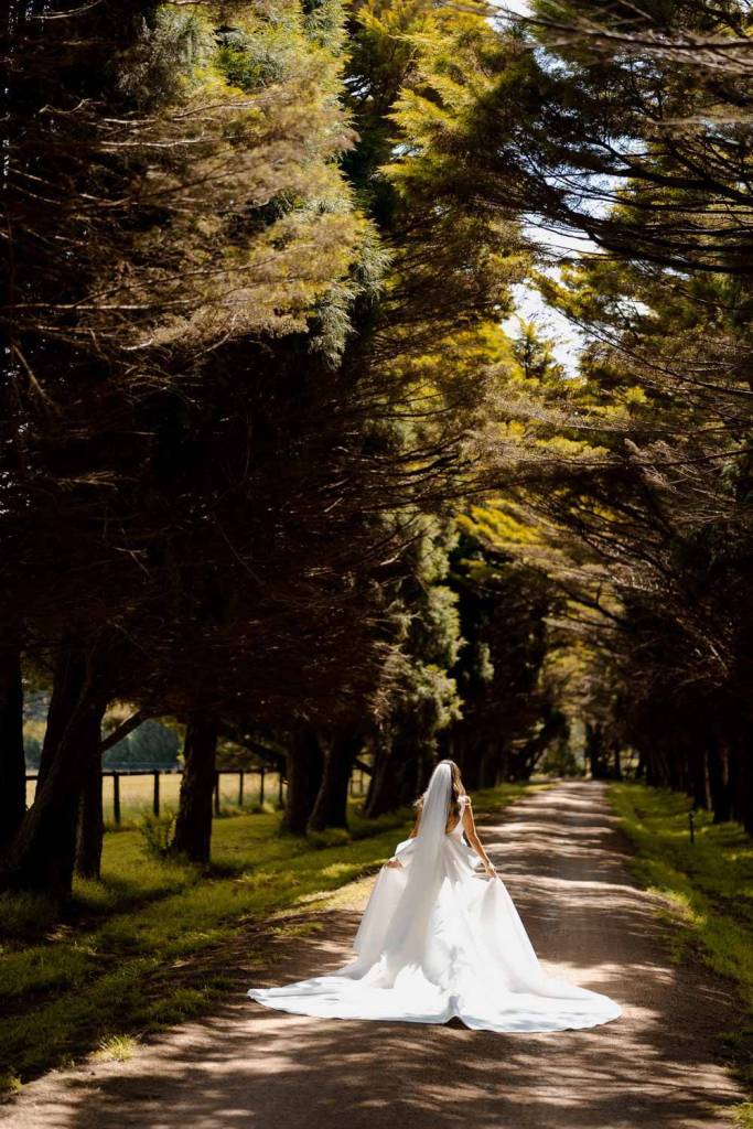 Bride in Yulia McCauley Wedding Dress between trees