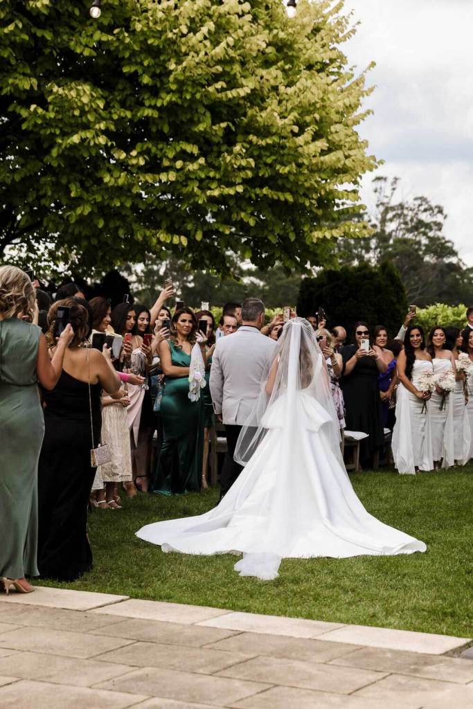 Brides long dress walking down aisle