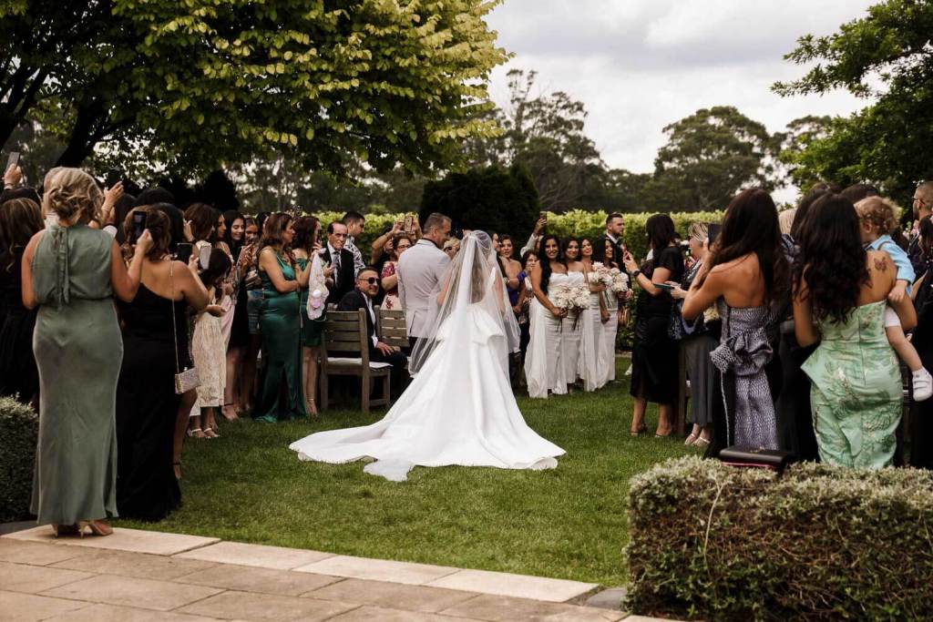 Brides long dress walking down aisle
