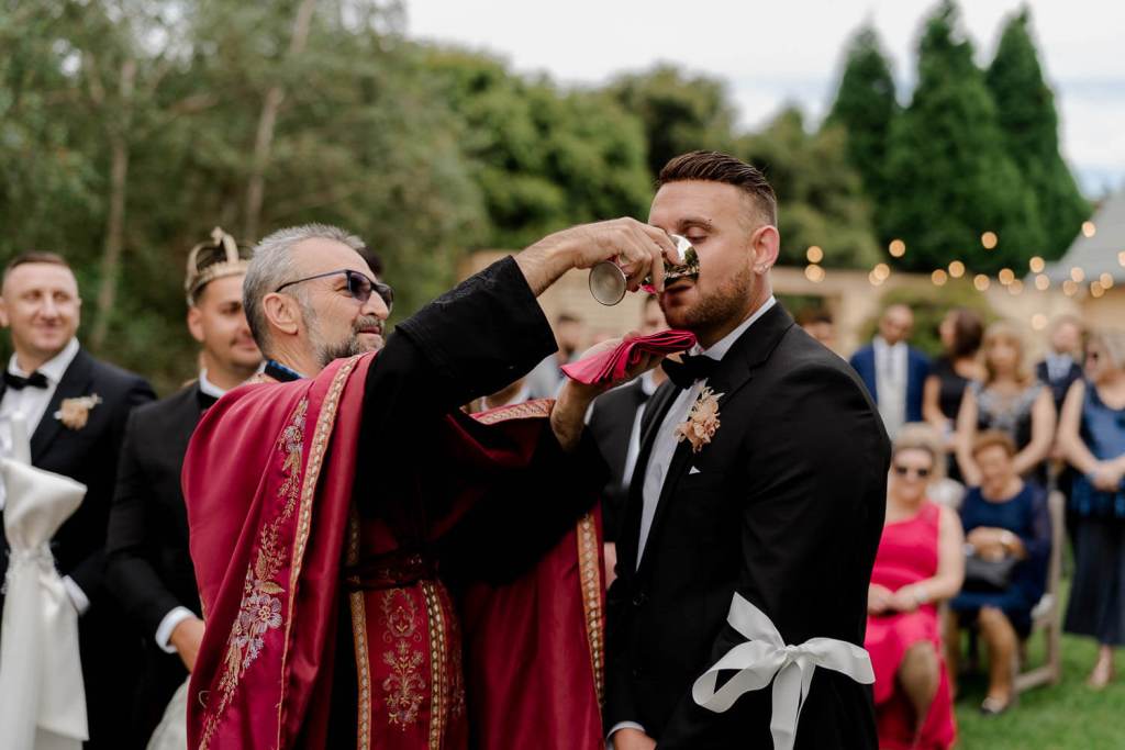 Groom drinking church wine