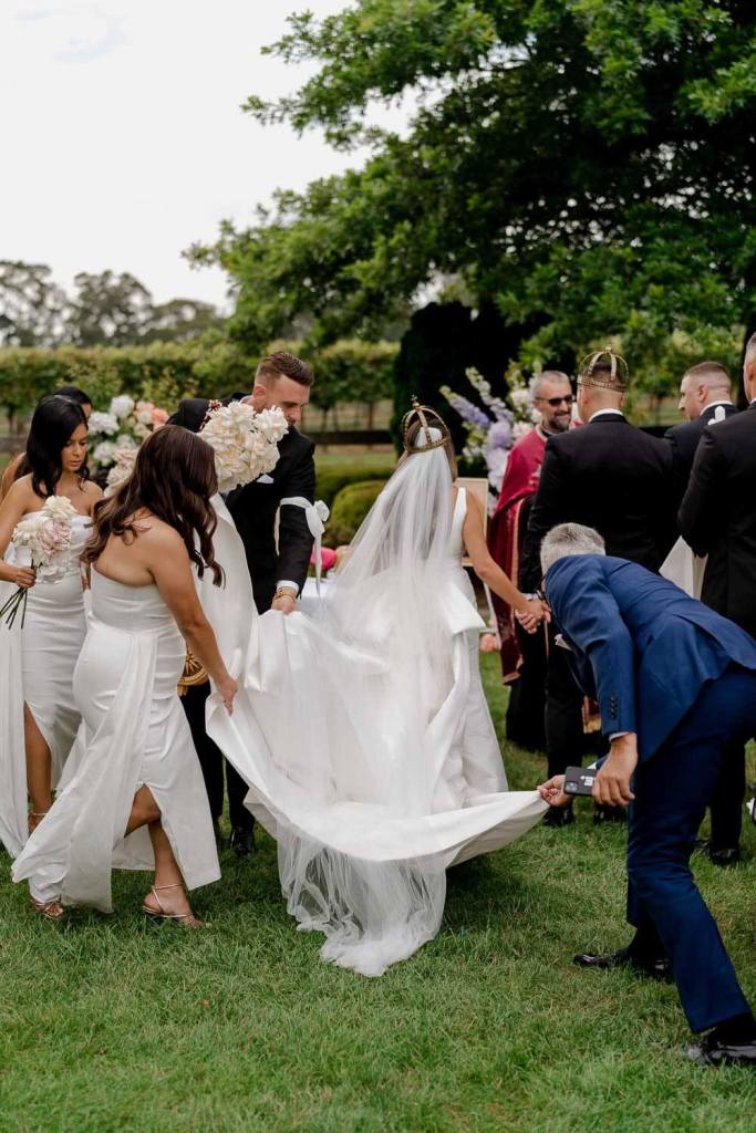 Bridesmaids holding brides dress