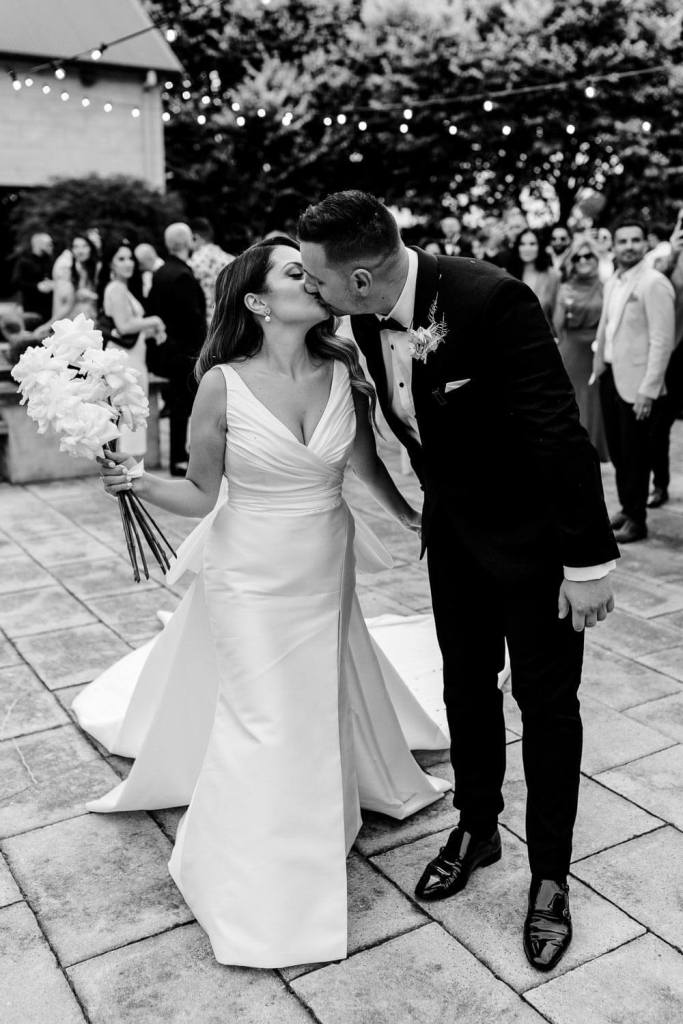 Bride and groom kissing black and white