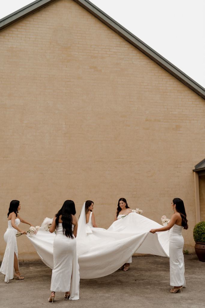 Bridesmaid holding brides dress