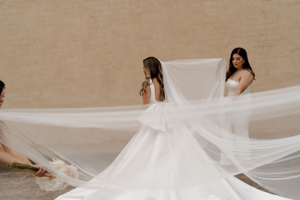 Bridesmaid holding brides dress
