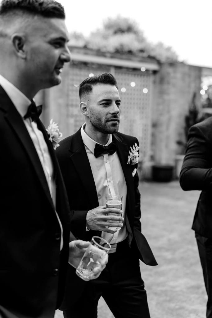 Groomsman smiling with drink