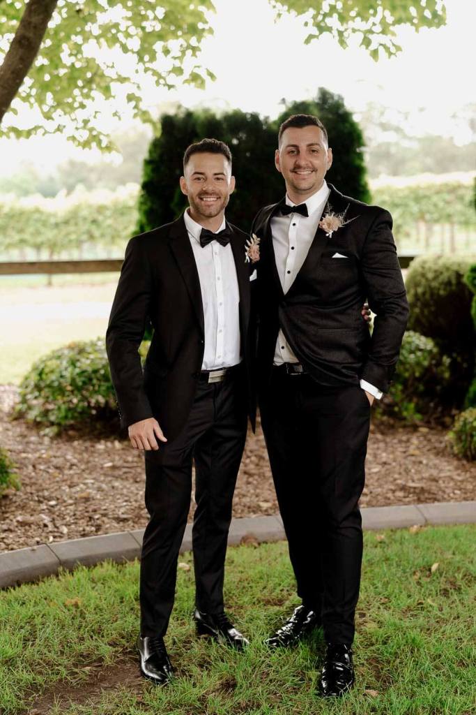 Groomsman smiling and standing on grass