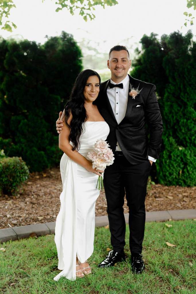 Bridal couple smiling in garden