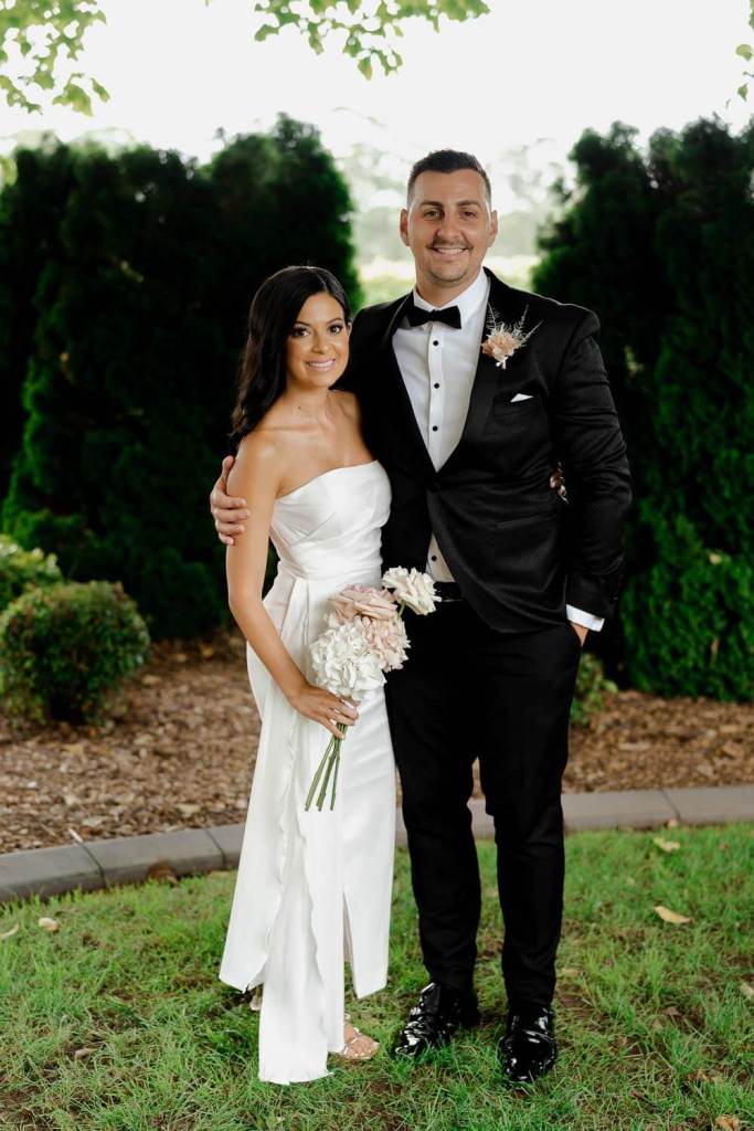 Bridal couple smiling in garden