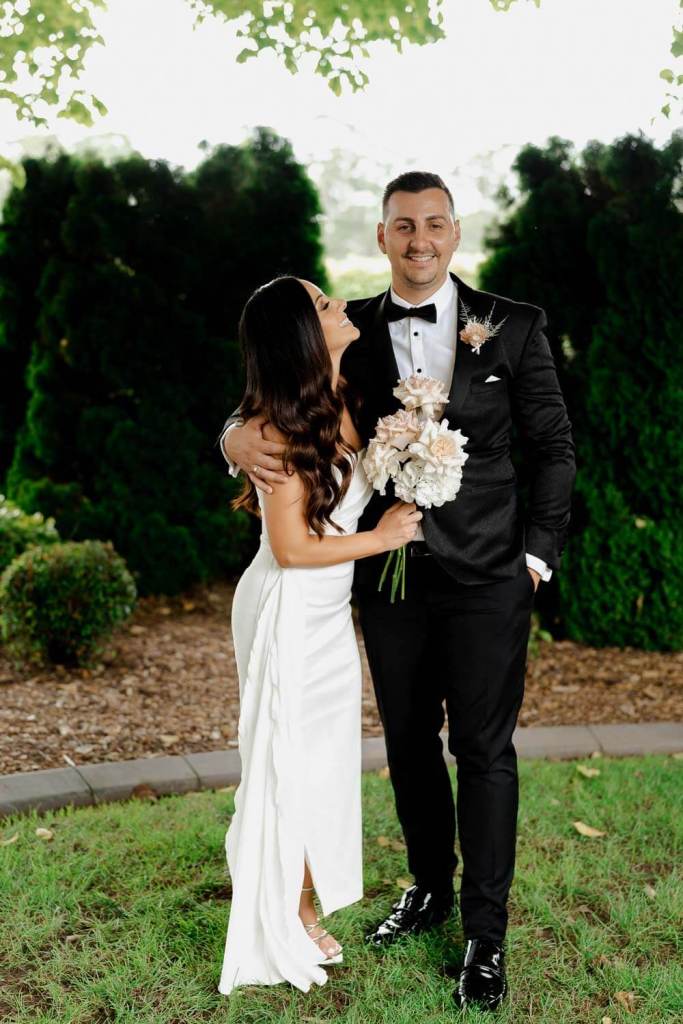 Bridal couple smiling in garden