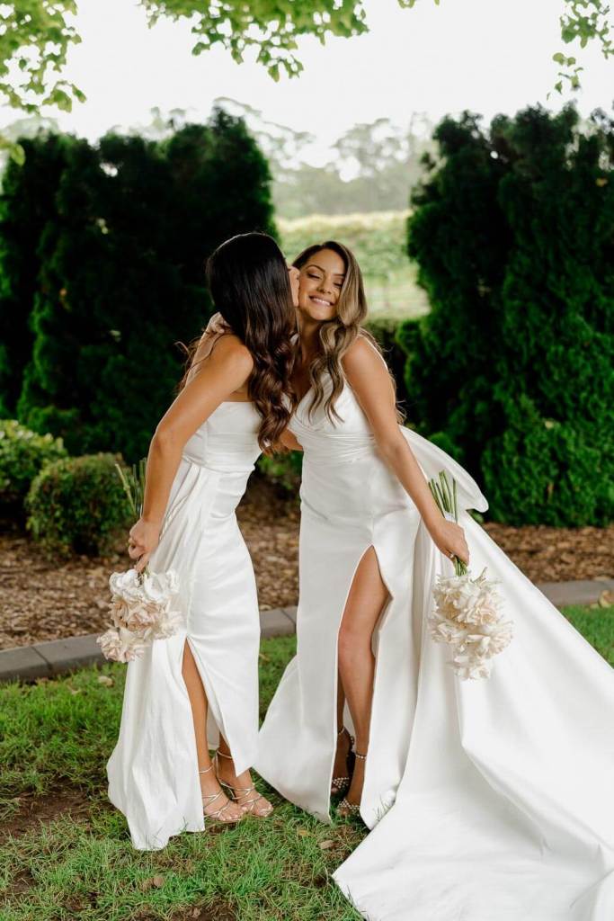 Bridesmaids kissing in garden