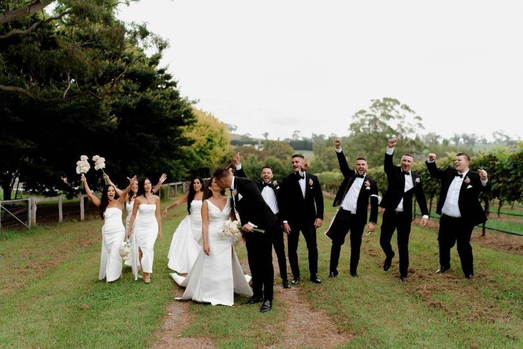 Kissing bride and groom with bridal party