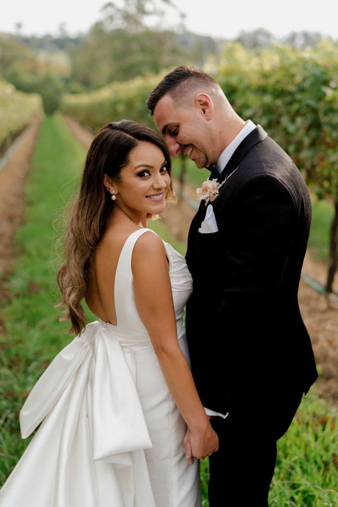 Bride and groom head touch smiling with groom