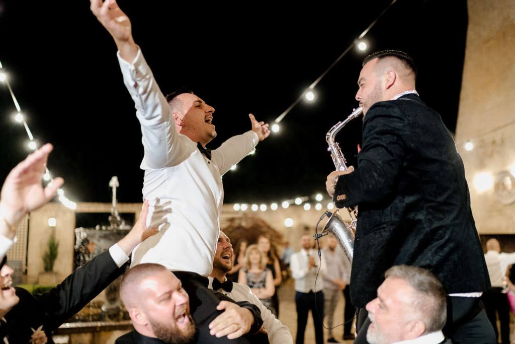 groom on guest shoulders dancing