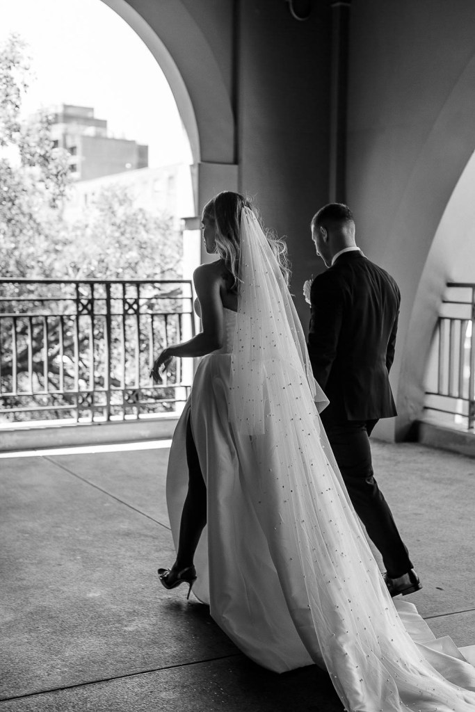 couple walking towards arch black and white
