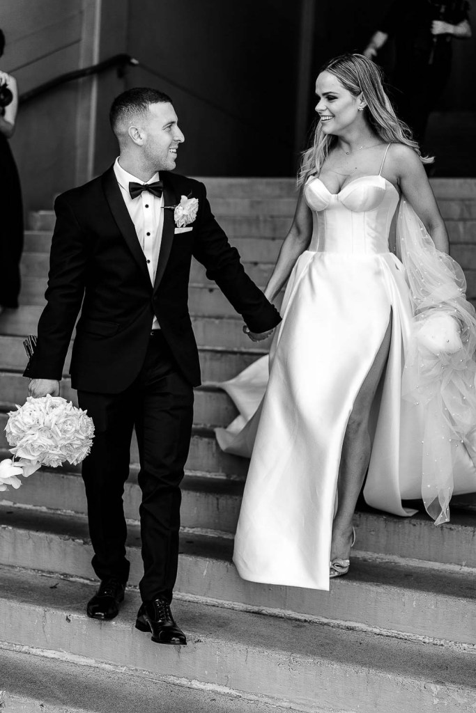 couple walk down stairs smiling black and white