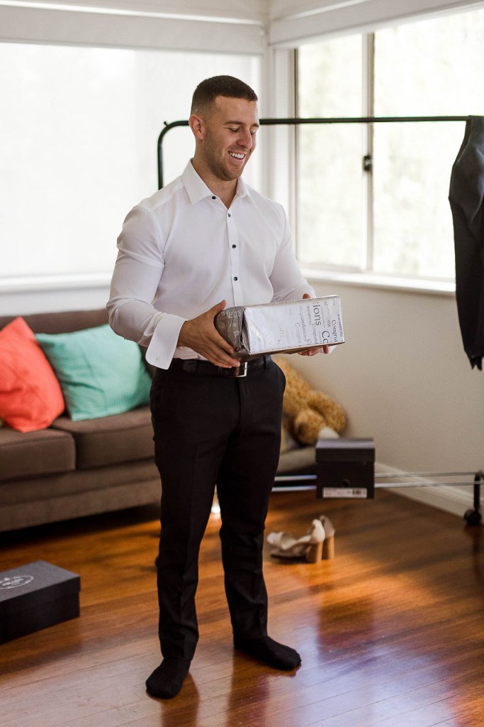 groom smiling with gift