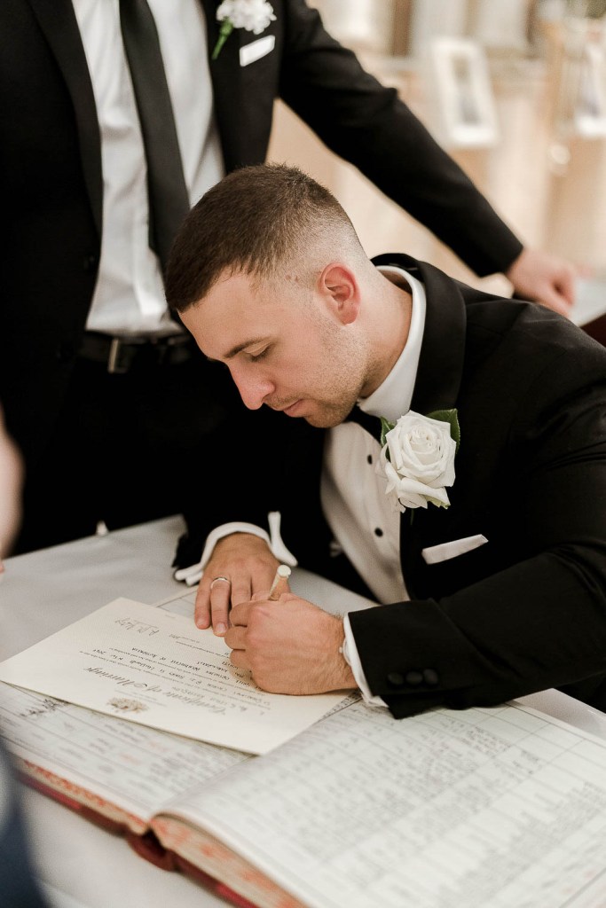 man signing marriage certificate